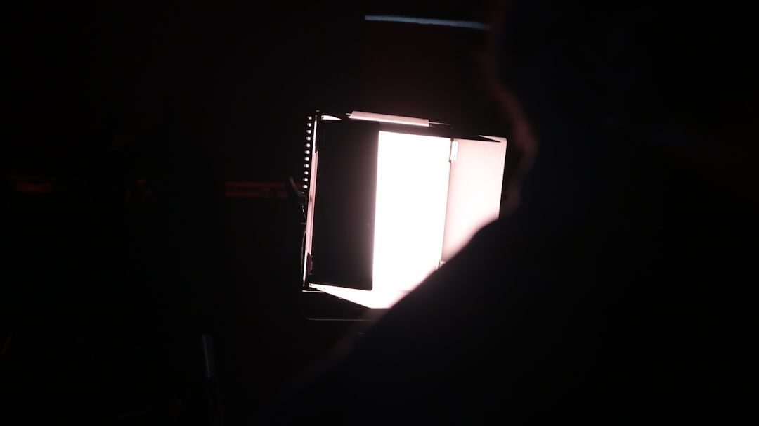 Lighting technician adjusting a studio softbox light on a rig